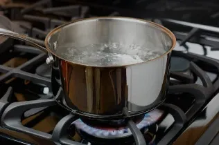Boiling water being prepared for a warm compress